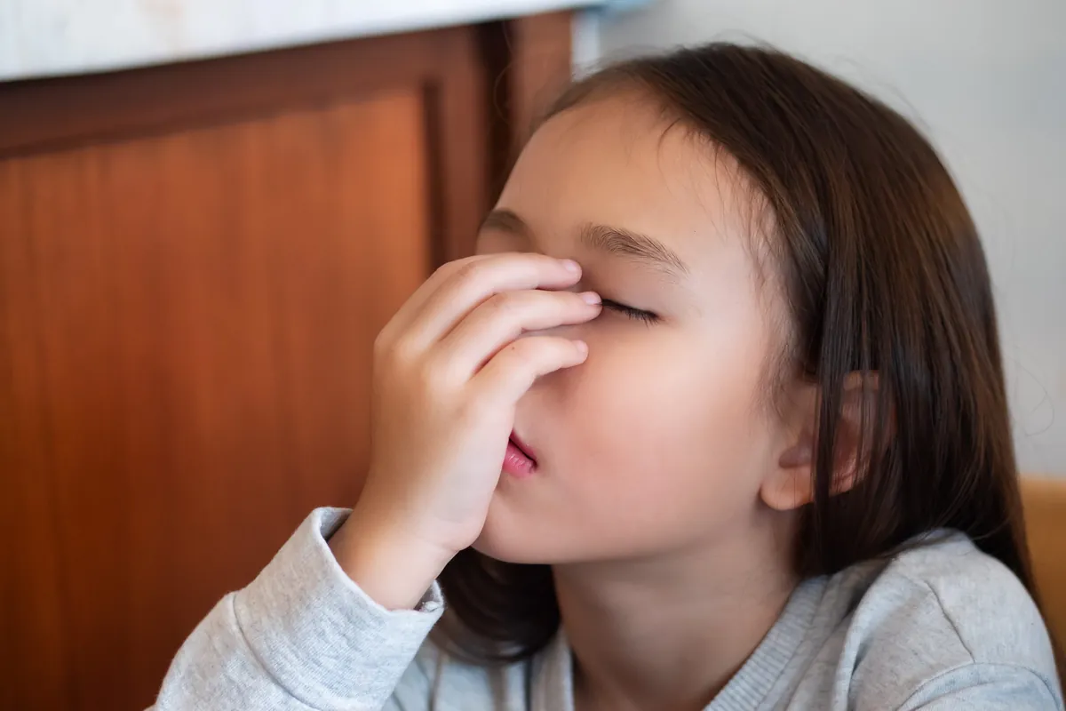 Young girl rubbing her irritated eyes